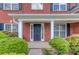 Close-up of a brick home's entrance with a black door and manicured landscaping at 1657 Hampton Woods Way, Lawrenceville, GA 30043