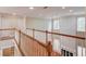 Second floor hallway with wood floors, banister and natural lighting at 1657 Hampton Woods Way, Lawrenceville, GA 30043