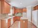Kitchen featuring wood cabinets, granite counters, tile floors, and modern appliances at 1657 Hampton Woods Way, Lawrenceville, GA 30043