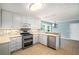 This is a kitchen with stainless steel appliances, white cabinets, and tile backsplash at 1978 Elmwood Cir, Snellville, GA 30078