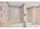 Bathroom featuring a tub, walk-in shower, patterned wallpaper, and tiled flooring at 524 Stephens Point Se Dr, Lawrenceville, GA 30045