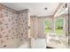 Bathroom with a tub, shower, patterned wallpaper, double sinks, and windows overlooking the landscape at 524 Stephens Point Se Dr, Lawrenceville, GA 30045