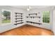 Bright bedroom with wood floors, two windows, and built-in shelving at 524 Stephens Point Se Dr, Lawrenceville, GA 30045