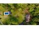 Aerial view showcasing a home, a pool, a pool house, and green space, all enveloped by lush trees at 8601 Flint Hill Rd, Douglasville, GA 30135