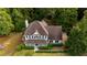 Aerial view of a beautiful two-story home nestled among mature trees, showcasing its pristine lawn and landscaping at 8601 Flint Hill Rd, Douglasville, GA 30135