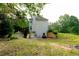 Rear exterior view of home and lush backyard with a driveway and additional parking at 8601 Flint Hill Rd, Douglasville, GA 30135