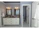 Neutral bathroom with double sinks, tiled floors, and a large door that leads to the toilet at 8601 Flint Hill Rd, Douglasville, GA 30135
