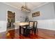 Dining room boasting modern light fixture, hardwood floors, decorative wainscoting and views into kitchen at 8601 Flint Hill Rd, Douglasville, GA 30135