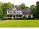 Inviting two-story home featuring a charming front porch and mature landscaping at 8601 Flint Hill Rd, Douglasville, GA 30135