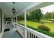Inviting covered front porch with decorative lighting and stunning views of landscaped front yard at 8601 Flint Hill Rd, Douglasville, GA 30135