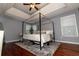 Spacious main bedroom with a canopy bed, tray ceilings, and wood floors at 8601 Flint Hill Rd, Douglasville, GA 30135
