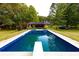 A sparkling in-ground pool with a diving board and lush landscaping offers a relaxing backyard oasis at 8601 Flint Hill Rd, Douglasville, GA 30135