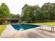 Backyard pool features a diving board and pergola, surrounded by a lush lawn and mature trees at 8601 Flint Hill Rd, Douglasville, GA 30135
