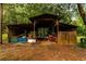 A rustic shed on a wooded lot provides ample space for storage and outdoor projects at 8601 Flint Hill Rd, Douglasville, GA 30135