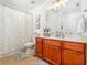 Bright bathroom featuring a wood vanity, large mirror, and a shower tub at 1029 Harvest Brook Dr, Lawrenceville, GA 30043