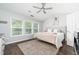 Bedroom with vaulted ceiling, ceiling fan, wood floors, large windows, and a neutral color scheme at 1029 Harvest Brook Dr, Lawrenceville, GA 30043