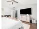 Bedroom featuring a ceiling fan, wood floors, and a dresser with a large television at 1029 Harvest Brook Dr, Lawrenceville, GA 30043