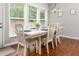Bright dining room features wood floors, modern chandelier, and a large window overlooking the backyard at 1029 Harvest Brook Dr, Lawrenceville, GA 30043