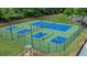 Aerial view of the blue and green tennis and pickleball courts with players at 1029 Harvest Brook Dr, Lawrenceville, GA 30043