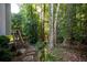 Backyard with wooded area, stepping stone path and wooden stairs going to the upper deck at 1304 Carrington Way, Lawrenceville, GA 30044