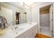 Updated bathroom with dual sinks, white cabinets, and a shower-tub combo, offering a functional space at 1304 Carrington Way, Lawrenceville, GA 30044