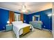 Bright bedroom with blue walls, accent furniture, and a large window, creating a serene retreat at 1304 Carrington Way, Lawrenceville, GA 30044
