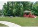 Community common area with pavilion, picnic tables, and green space surrounded by tall, mature trees at 1304 Carrington Way, Lawrenceville, GA 30044