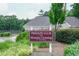 Flowers Crossing community sign with well-manicured landscaping and the clubhouse in the background at 1304 Carrington Way, Lawrenceville, GA 30044