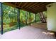 View of the covered deck with stairs leading up to the backyard, surrounded by a lush, wooded landscape at 1304 Carrington Way, Lawrenceville, GA 30044