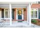 Charming covered front porch featuring a brick facade and painted columns at 1304 Carrington Way, Lawrenceville, GA 30044