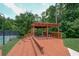 View of the wooden pavilion with a grill and picnic table overlooking the tennis court at 1304 Carrington Way, Lawrenceville, GA 30044