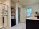Bright bathroom featuring a glass-enclosed shower, dual vanities, and a storage tower for towels and toiletries at 3836 Saddle Hill Way, Douglasville, GA 30135