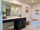 Bathroom featuring a vanity with a large mirror, soaking tub, and modern fixtures at 3836 Saddle Hill Way, Douglasville, GA 30135