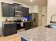 Modern kitchen with granite countertops, stainless steel appliances, dark cabinets, and wood-look flooring at 3836 Saddle Hill Way, Douglasville, GA 30135