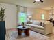 Bright living room featuring a large sectional sofa, area rug, large window with views, and modern furnishings at 3836 Saddle Hill Way, Douglasville, GA 30135