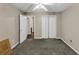 An empty carpeted room with neutral walls and multiple doors providing access to closets and other areas at 4375 Split Creek Dr, Douglasville, GA 30135