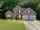 Charming two-story brick home with a well-manicured lawn and an attached two-car garage at 4375 Split Creek Dr, Douglasville, GA 30135