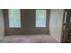 Bedroom with carpeted floor and two windows overlooking the yard at 2858 Parkway Close, Lithonia, GA 30058