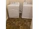 Bright laundry room with white washer and dryer and neutral tile floor at 2858 Parkway Close, Lithonia, GA 30058
