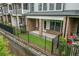 Townhome backyard with black metal fence, brick walls, concrete patio, and small yard at 240 Walker Ave, Roswell, GA 30076