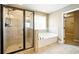 Bathroom with tile shower, separate soaking tub, tile flooring, and a walk-in closet at 3740 Lake Enclave Way, Atlanta, GA 30349