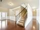 A foyer with hardwood floors, paneled walls, front door, and carpeted staircase at 3740 Lake Enclave Way, Atlanta, GA 30349