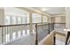 Upstairs hallway featuring wood railing with black iron balusters overlooking the living area below at 3740 Lake Enclave Way, Atlanta, GA 30349