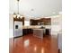 A kitchen with stainless steel refrigerator, dark cabinetry, island, and hardwood floors at 3740 Lake Enclave Way, Atlanta, GA 30349