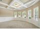 Open living room with coffered ceilings, chair rails, and large windows providing natural light at 3740 Lake Enclave Way, Atlanta, GA 30349