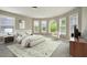 A main bedroom with windows, a bed, and modern furniture at 3740 Lake Enclave Way, Atlanta, GA 30349