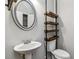 The half bathroom has a unique industrial shelving unit and a modern sink design at 6094 Whitetail Deer Run, Mableton, GA 30126