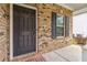 Close-up of the front door with brick facade and charming black shutters at 6094 Whitetail Deer Run, Mableton, GA 30126