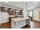 Well-lit kitchen features an island with granite countertops, stainless steel appliances, and modern dark-brown cabinets at 6094 Whitetail Deer Run, Mableton, GA 30126