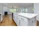Open-concept kitchen island featuring a sink and seating area, flowing into the living room with a fireplace at 740 Pineberry Ct, Grayson, GA 30017